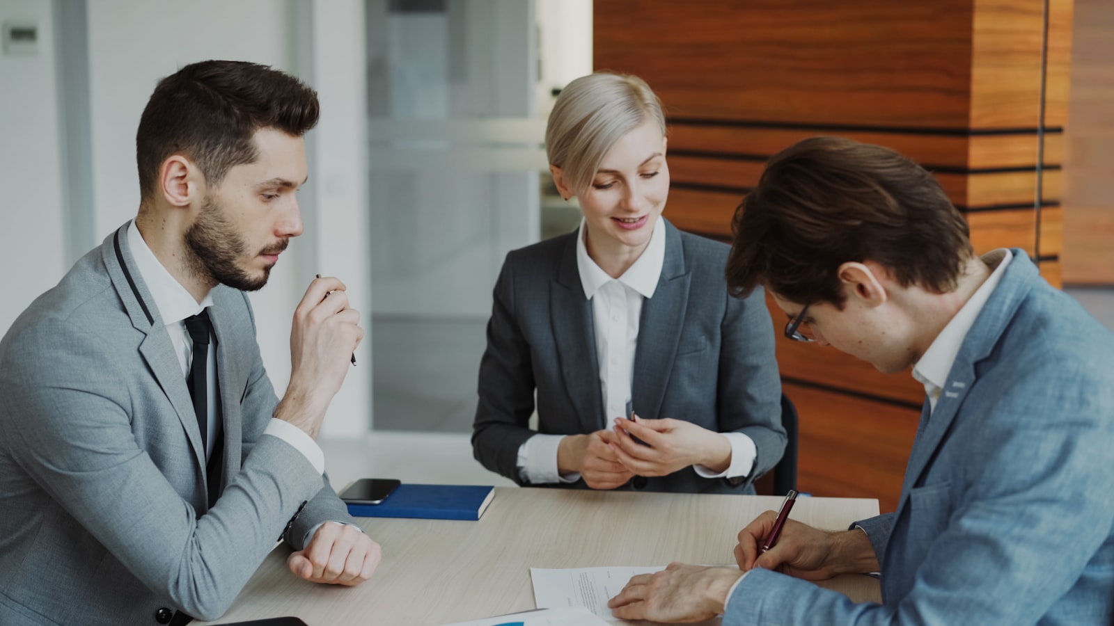 Profissionais revisando contrato em reunião empresarial