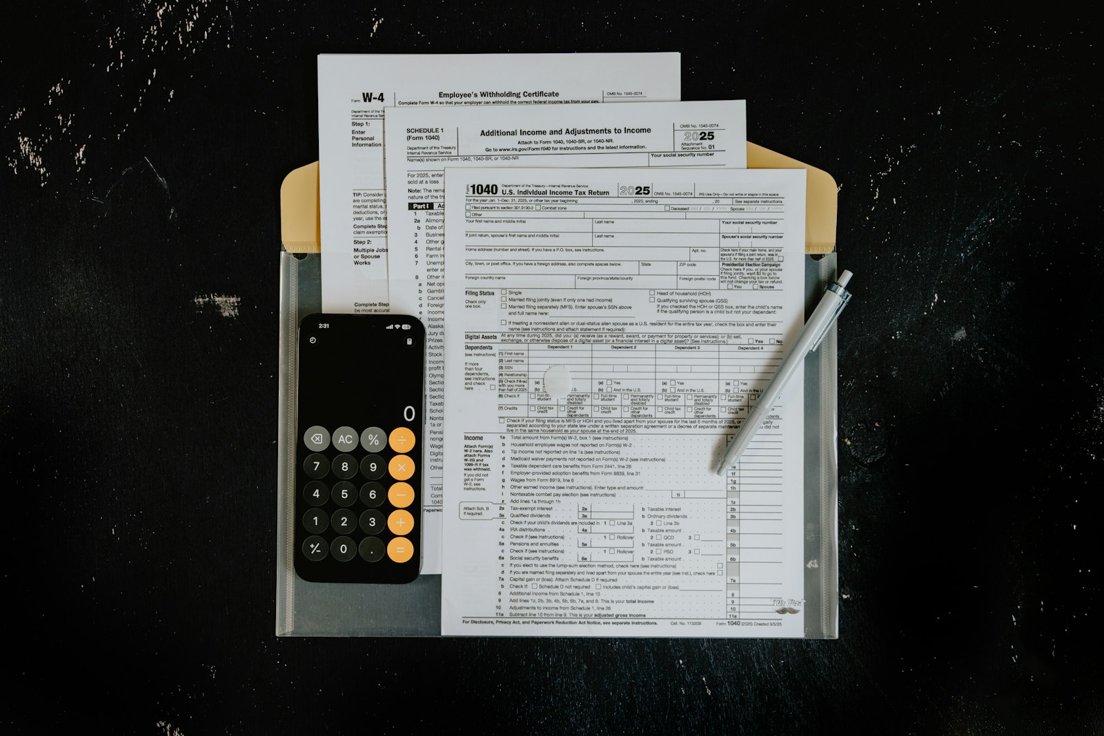 Formulários fiscais, calculadora e caneta sobre mesa escura